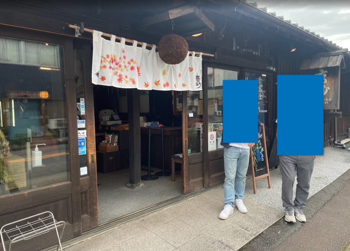 富士高砂酒造の店の入口。紅葉柄ののれんと杉玉が下がり、店内にカウンターが見える