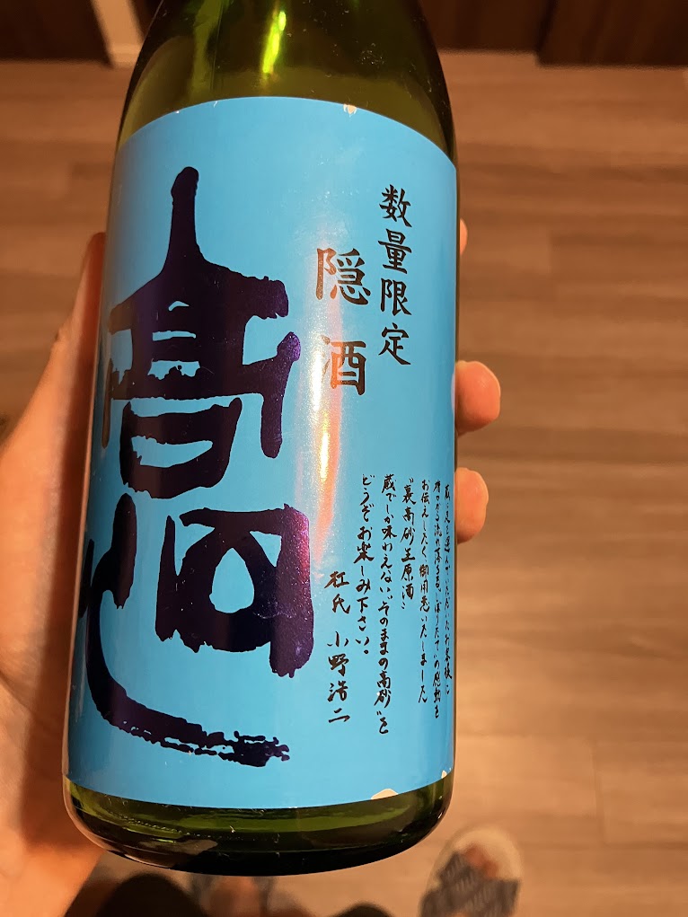 高砂 隠酒（純米吟醸 生原酒）の表ラベル。水色の地に紫の「高砂」の文字