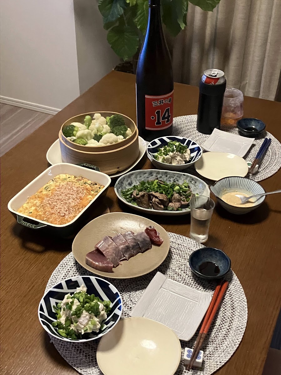 三井の寿 +14の一升瓶とグラス、せいろの蒸し野菜や塩鶏レバー、カツオが並ぶ夕食の食卓